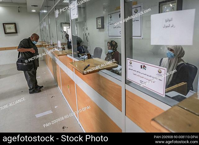 08 September 2020, Palestinian Territories, Gaza City: A Palestinian man receives financial aid at the post office in Gaza City as part of a Qatari aid program...