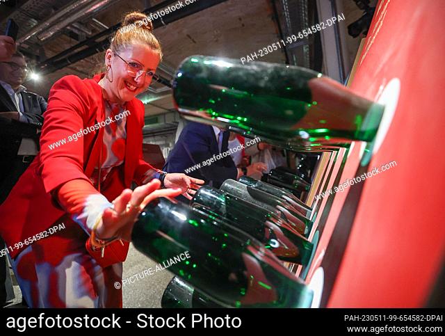 11 May 2023, Saxony-Anhalt, Freyburg (Unstrut): Kati Fritzsche, head of the world of experience, rattles bottles in a bet with traditional bottle fermentation...