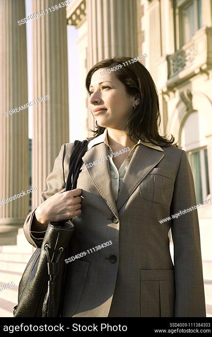 Hispanic businesswoman in front of building