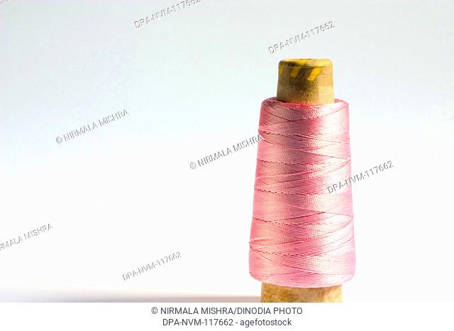 Concept , one cylindrical shape crochet silky shiny pink Color thread on white background