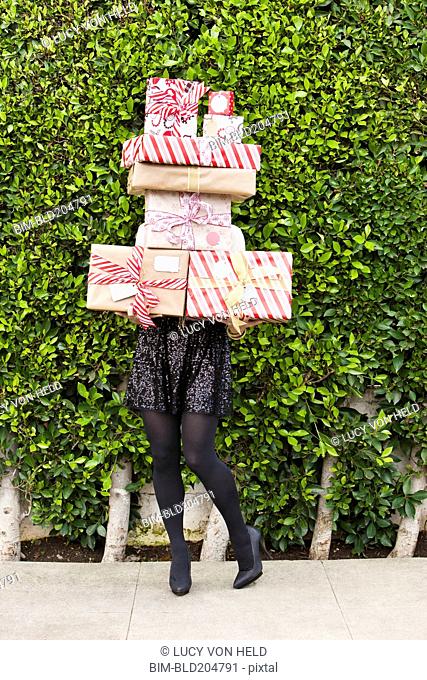 Caucasian woman carrying Christmas gifts