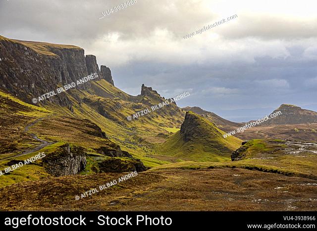 The Quiraing, big cliff, cloudy day, sun rays, mountain landscape, Skye Island, Highlands, Scotland