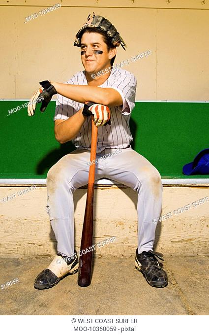 Baseball player sitting in dugout