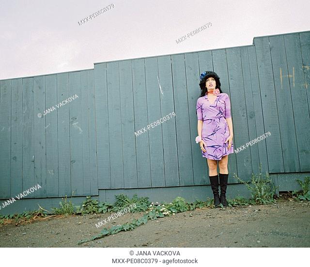 Woman standing by fence