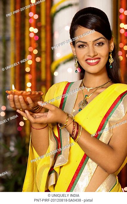 Woman holding an oil lamp on Diwali