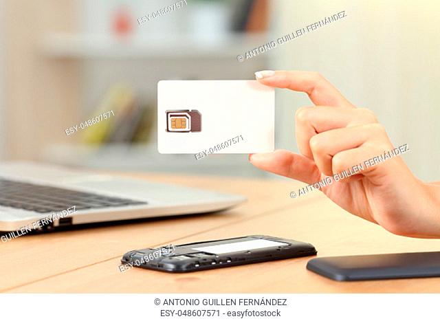 Close up of a woman hand holding a blank new sim card at home