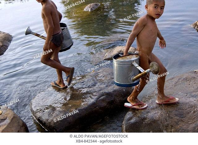 Laos, Bolaven plateau, Se Set river, two young boys carrying water from the river for irrigation