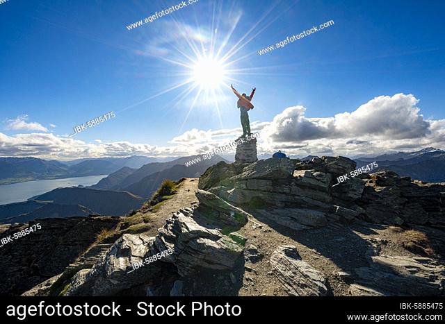 Hiker stretches out his arms in the air, summit of Ben Lomond, view of Lake Wakatipu, Southern Alps, Otago, South Island, New Zealand, Oceania