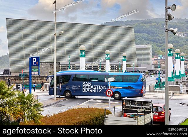 Tourist bus circulating along República Argentina Street and the Zurriola Bridge, next to the Urumea River, in the background Kursaal Palace, Donostia