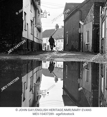 View from the rear of the White Hart Hotel, Wickham Market, looking towards the High Street, with the scene reflected in a large puddle, Suffolk