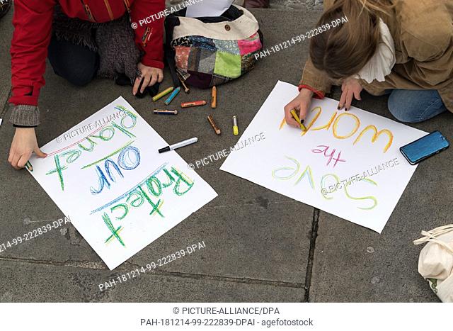14 December 2018, Berlin: Students demonstrate in the city centre under the motto ""Future without climate chaos"" and paint posters with the inscription ""save...