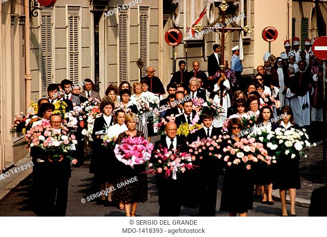 Procession during the funeral of Princess Grace. Procession of men and women carrying bunches of flowers towards the Cathedral