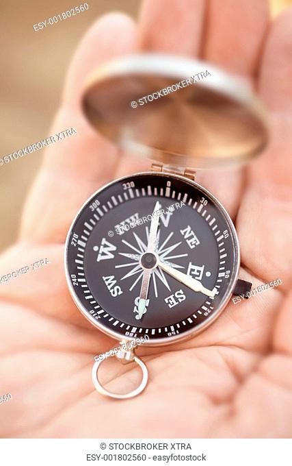 small compass on the hand, selective focus, lens blur