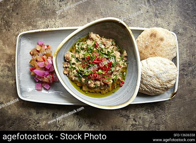 Hummus in a bowl with salad and flatbreads
