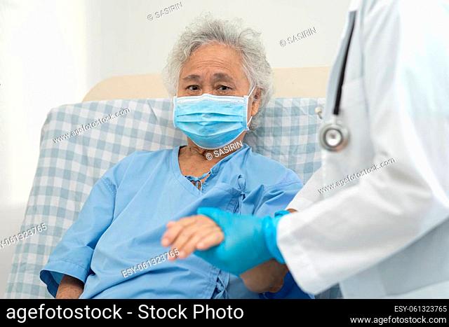 Doctor help Asian senior or elderly old lady woman patient wearing a face mask in hospital for protect safety infection and kill Covid-19 Coronavirus
