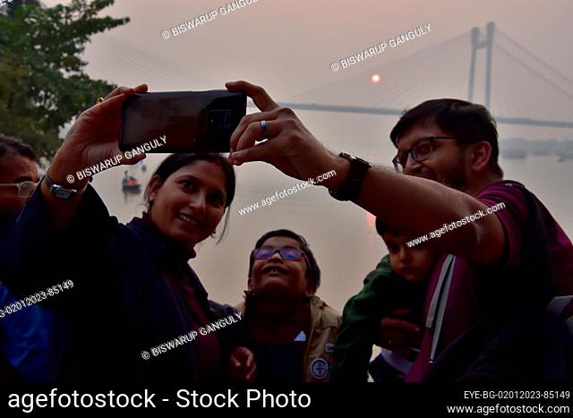 Dec 31, 2022, Kolkata, India. A person takes a selfie during the sunset across the  Howrah Bridge (Vidyasagar Setu) On River Ganges