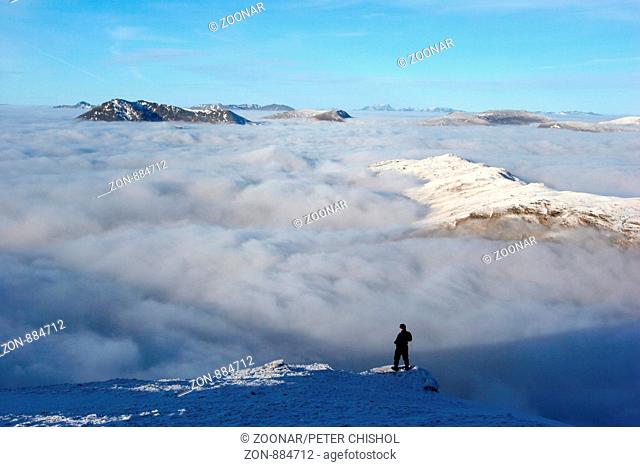 Hillwalker on Ben Challum looking across a cloud inversion to Beinn Dorain
