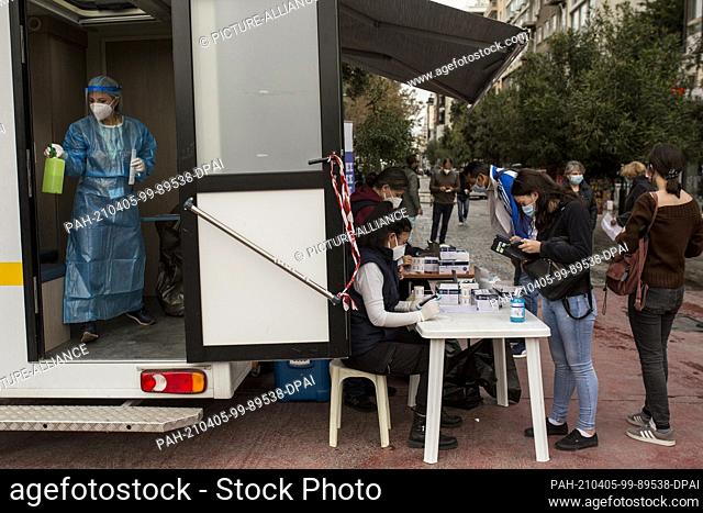05 April 2021, Greece, Athen: People wait to take a rapid antigen test during the Corona pandemic, conducted by a mobile testing unit of the National...