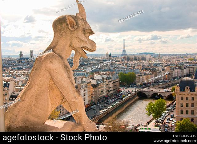 Gargoyle on Notre Dame Cathedral and city of Paris close up, France