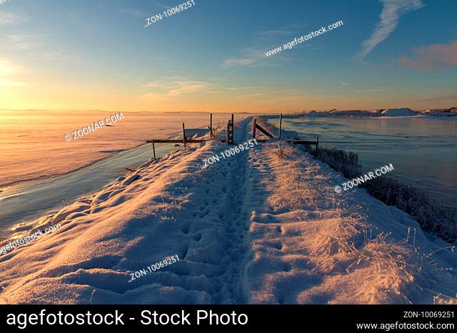 Winter landscape with snow, sea, ocean, ice, blue sky, road with snow, sunshine. Norway, Fredrikstad, Nature Reserve. This is an important area for birds and...