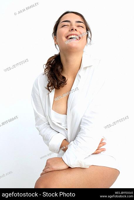 Happy young woman wearing shirt against white background