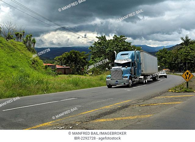 Road, large truck and storm clouds in front of San Jose, Alajuela Province, Costa Rica, Central America