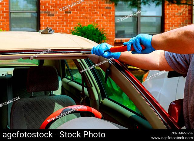 Workers removing glazing car replacement crack broken windscreen car in the car service