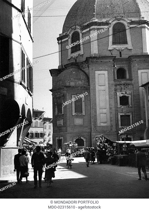 People walking in a street beside the basilica of Saint Lawrence. Florence, September 1955