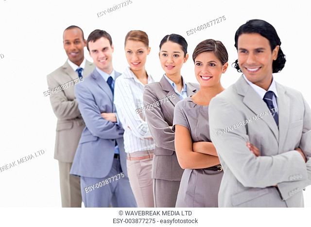 Close-up of a business team smiling in a single line looking towards the left side with focus on the first woman
