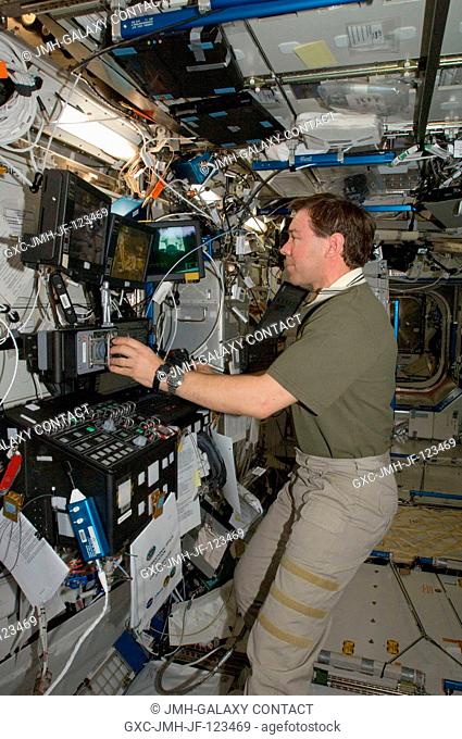 Astronaut Michael Barratt, Expedition 1920 flight engineer, works the controls at the Canadarm2 robotic work station in the Destiny laboratory of the...