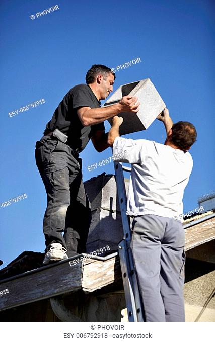 Roofers installing chimney