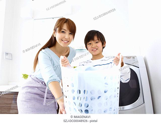 Mother with son holding a laundry basket