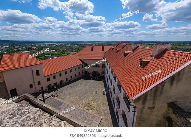Fascinating view from above into the courtyard of the castle against the background of the city of a blue cloudy sky in the background