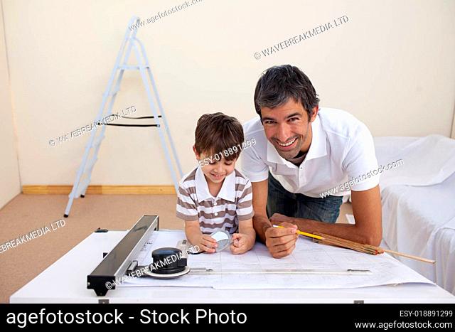 Father and son making architectural works in bedroom