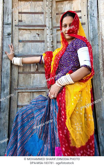 Rajasthani woman giving pose wearing traditional dress in front house jodhapur rajasthan India MR#786