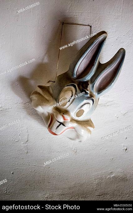 Rabbit mask hangs on a wall