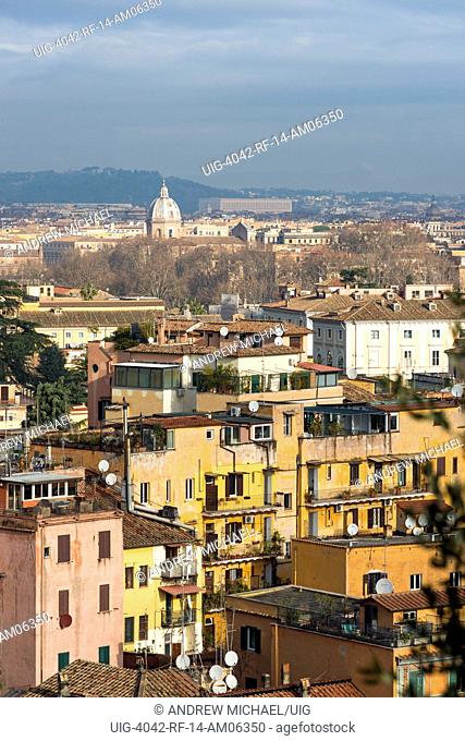 Views across Rome city with colorful old apartments in foreground, seen from Gianicolo or Janiculum Hill, Trastevere, Rome, Italy