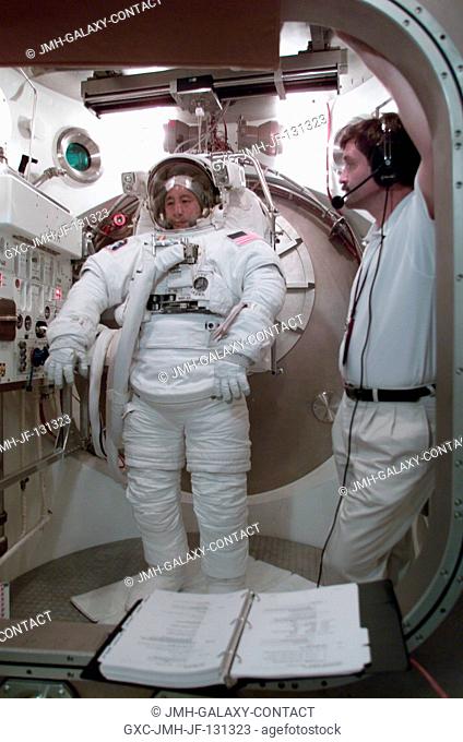 Astronaut Edward T. Lu, Expedition Seven flight engineer, participates in an Extravehicular Mobility Unit (EMU) spacesuit fit check in a Space Station Airlock...