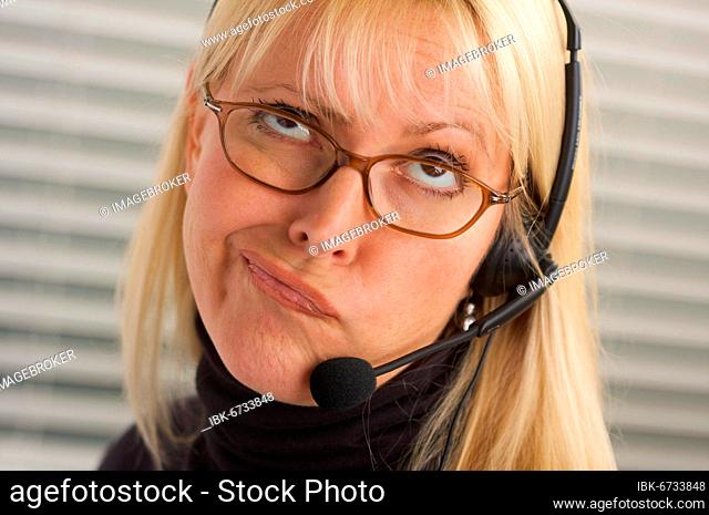 Goofy businesswoman talks on her phone headset