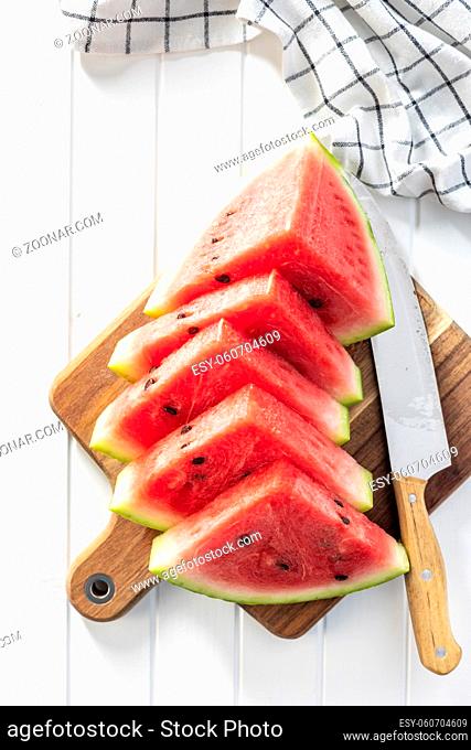 Red sliced watermelon. Pieces of red melon on cutting board. Top view