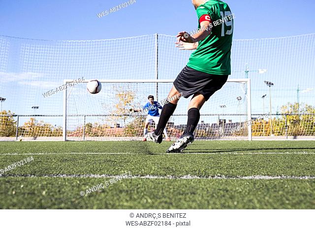 Football player shooting the ball on football field