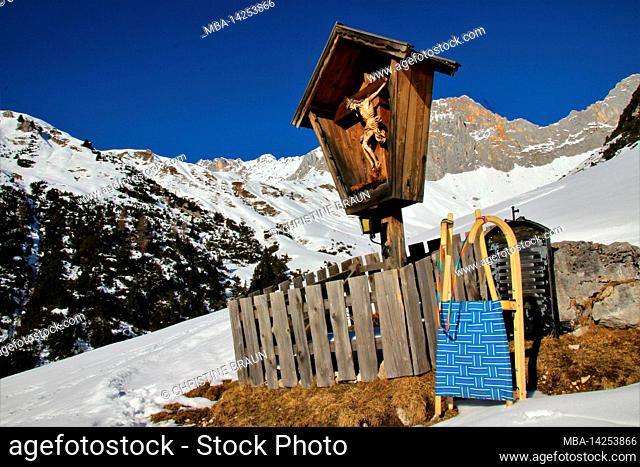 Winter hike to the Wang Alm in the Gaistal, sledges in front of a mountain cross, mountain scenery in the snow, Austria, Tyrol, vacation, winter, dream weather