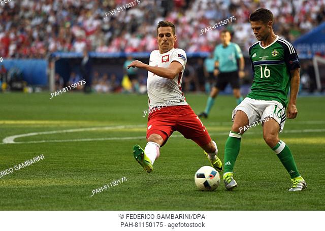 Arkadiusz Milik (L) of Poland and Oliver Norwood (R) of Northern Ireland challenge for the ball during the UEFA Euro 2016 Group C soccer match between Poland...