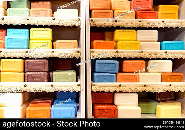 Many colorful bars of soap stacked in a wooden cabinet