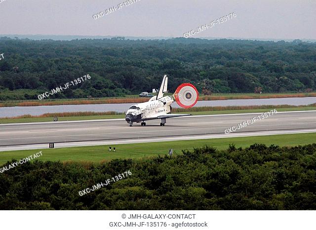 With drag chute deployed, Space Shuttle Discovery slows to a stop after landing on runway 15 at Kennedy Space Center's Shuttle Landing Facility at 9:14 a