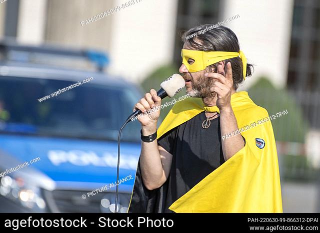 30 June 2022, Berlin: Michael Bründel aka Captain Future speaks at a rally in front of the Brandenburg Gate after the arrest of ""Querdenken"" founder Ballweg...