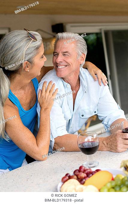 Caucasian couple drinking wine at table