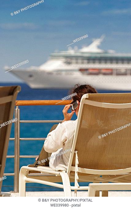 Woman with a cell phone on a deck, Cozumel, Mexico