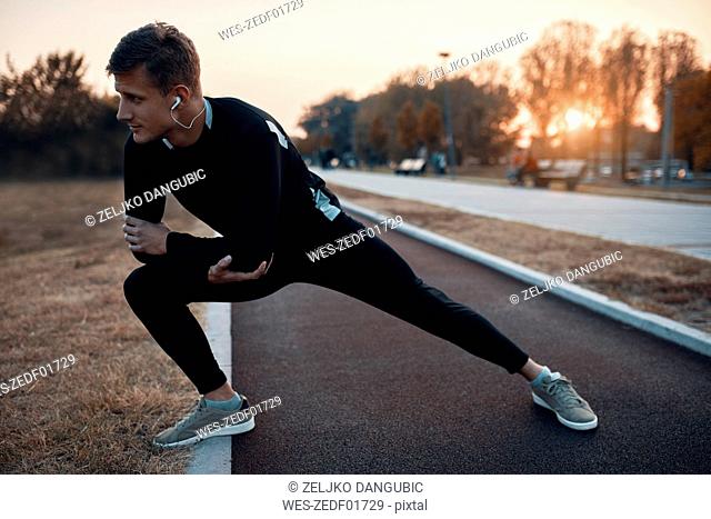 Sportive man stretching in the evening