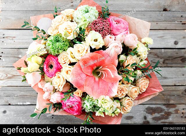 mix flowers bouquet on wooden background. old rustic table, a coil of twine and garden secateurs. top view